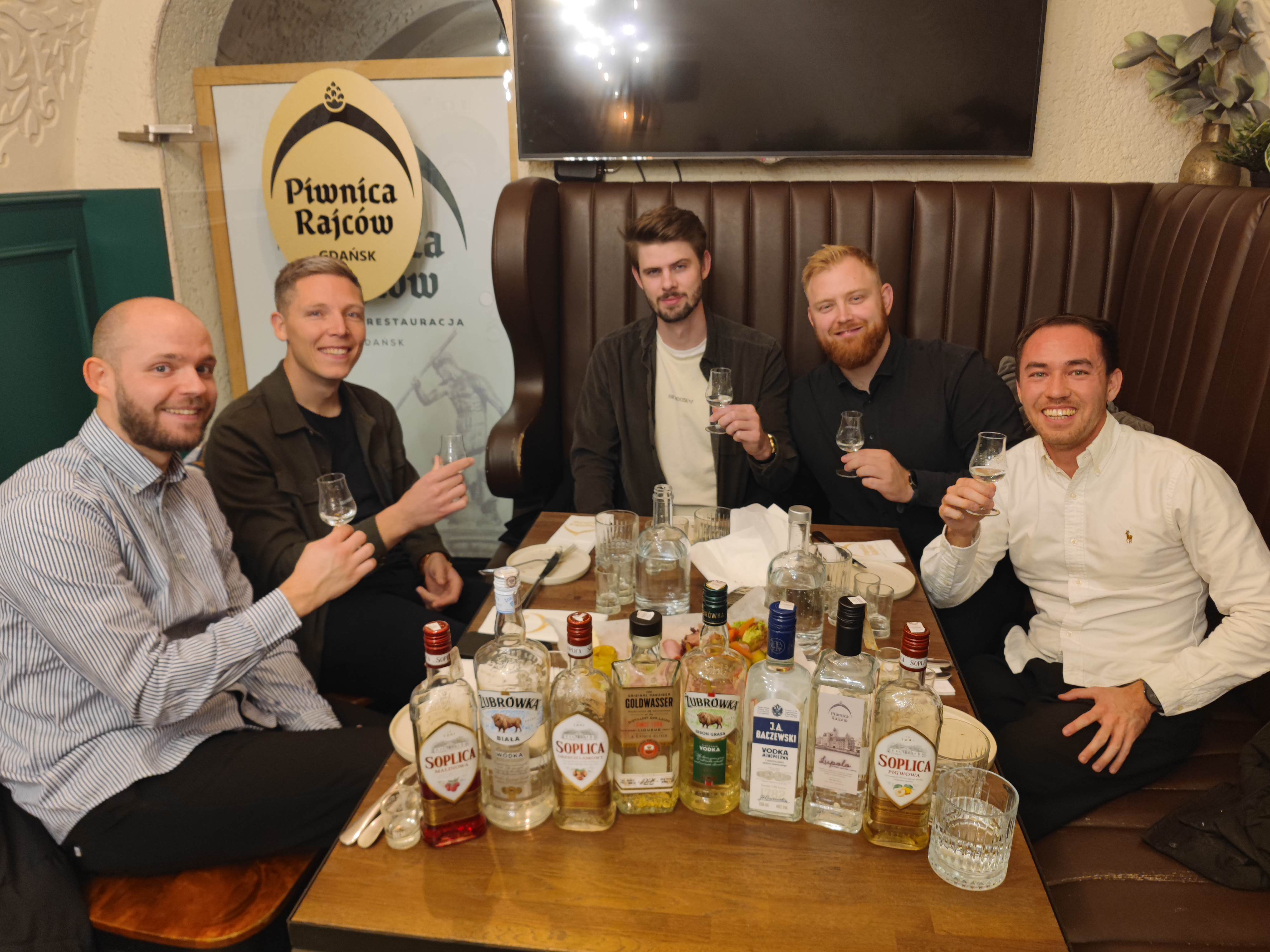 Guests raising tasting glasses during a Polish vodka experience in Poland